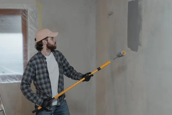 Painter rolling grey paint onto an interior wall in Santa Rosa